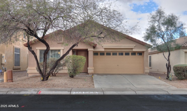 view of front of home with a garage, driveway, a tiled roof, and stucco siding