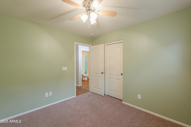 unfurnished bedroom with carpet floors, a closet, baseboards, and a ceiling fan