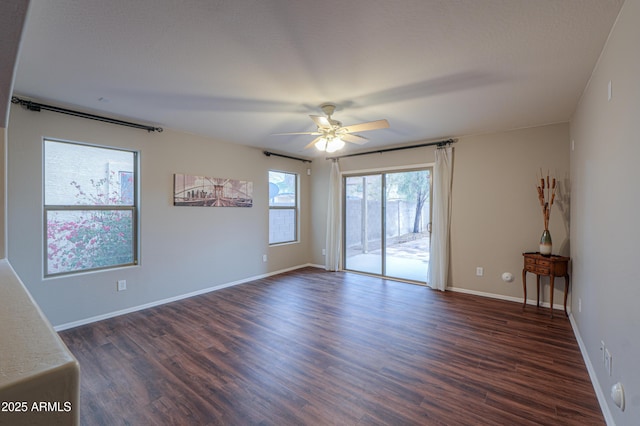 unfurnished room featuring a ceiling fan, baseboards, and dark wood-type flooring