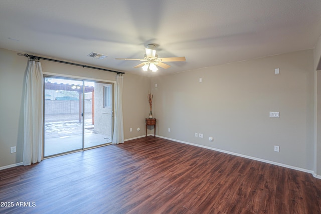 unfurnished room featuring dark wood-style flooring, visible vents, and baseboards