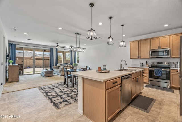 kitchen featuring a sink, appliances with stainless steel finishes, open floor plan, and light countertops