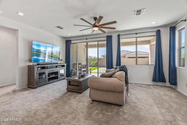 carpeted living room with visible vents, plenty of natural light, and baseboards