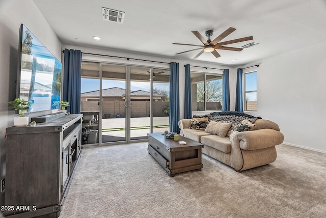 carpeted living area featuring visible vents, baseboards, and ceiling fan