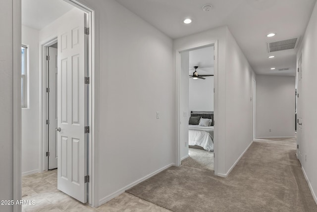 hall featuring recessed lighting, visible vents, and light colored carpet