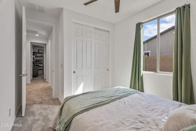 bedroom with a closet, visible vents, ceiling fan, and carpet