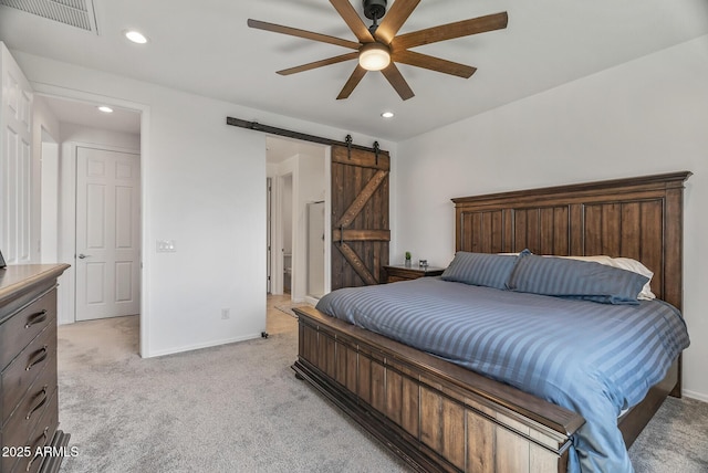 bedroom with visible vents, baseboards, recessed lighting, a barn door, and light colored carpet