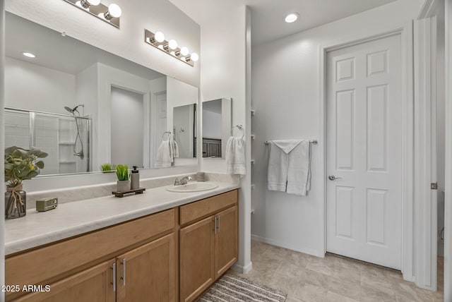 bathroom featuring vanity, recessed lighting, baseboards, and a shower with door