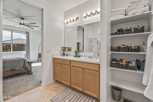 ensuite bathroom featuring vanity, a ceiling fan, baseboards, ensuite bath, and tile patterned flooring