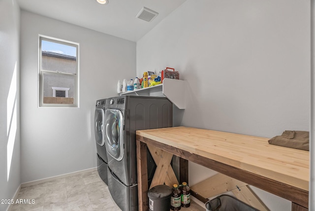 clothes washing area with visible vents, baseboards, washing machine and dryer, and laundry area