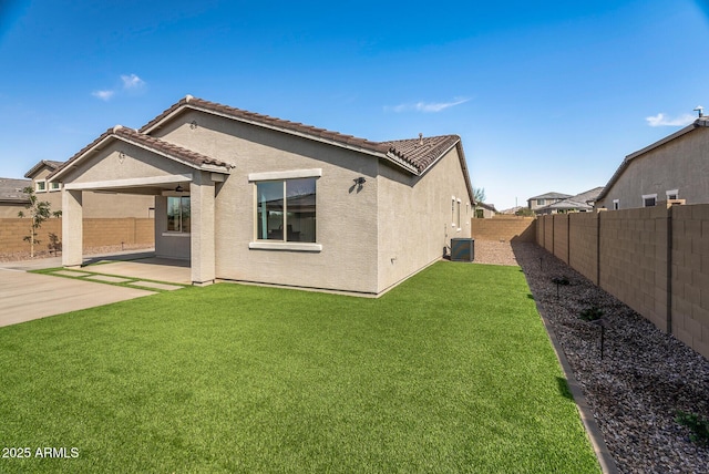 back of property with a patio, cooling unit, a fenced backyard, stucco siding, and a lawn