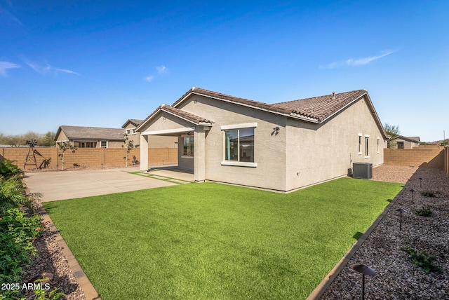 rear view of property featuring a tile roof, a patio area, a fenced backyard, and stucco siding