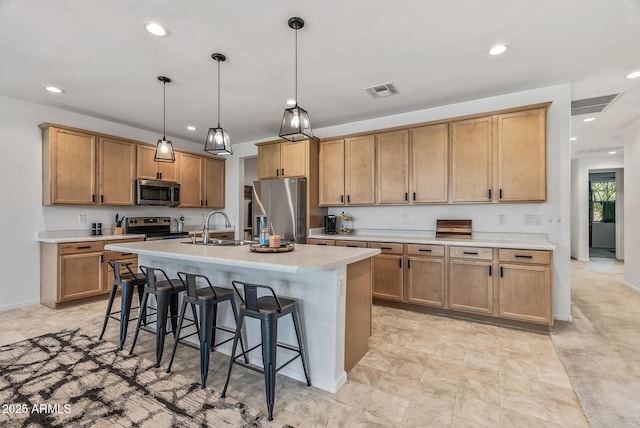 kitchen featuring visible vents, a sink, a kitchen breakfast bar, stainless steel appliances, and light countertops