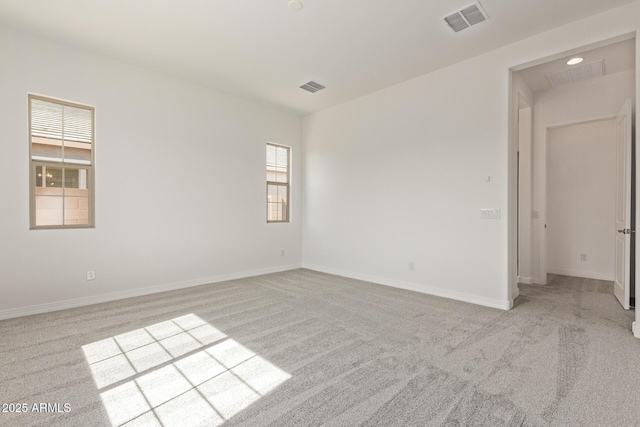 spare room with baseboards, visible vents, and carpet flooring