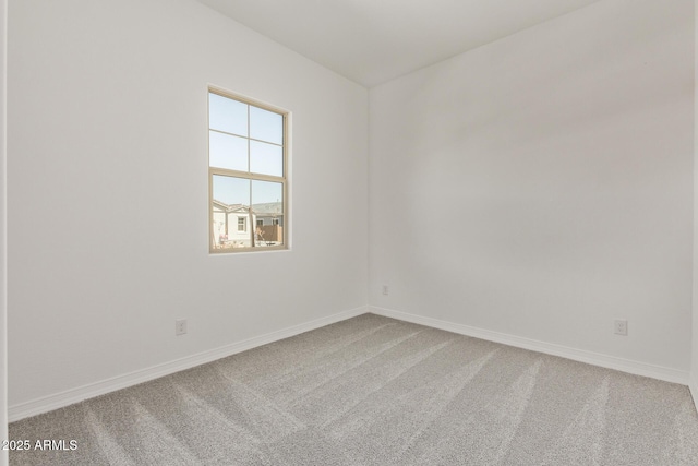unfurnished room with baseboards and carpet flooring