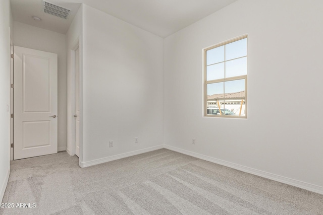 empty room with baseboards, visible vents, and carpet