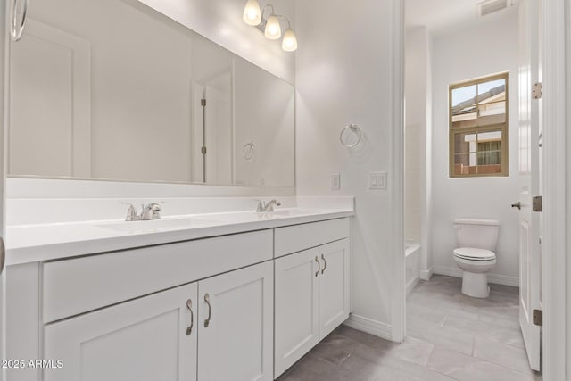 full bathroom with double vanity, toilet, baseboards, and a sink