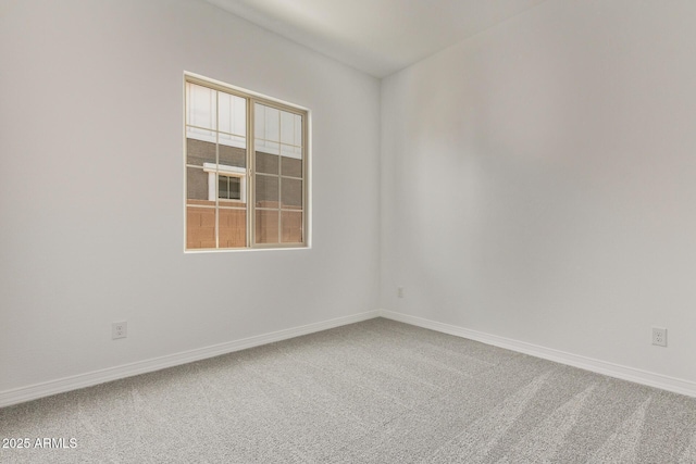empty room featuring carpet floors and baseboards
