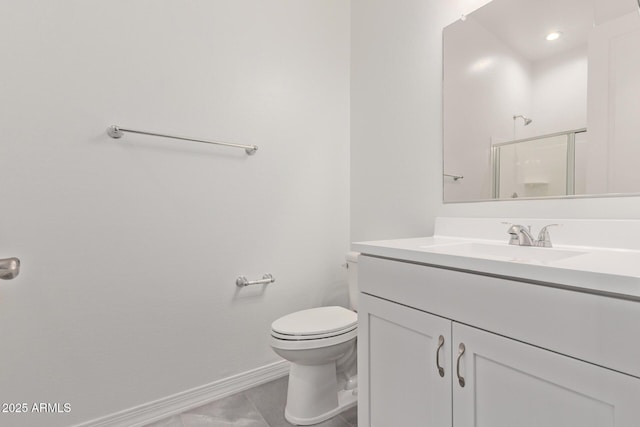 full bath featuring toilet, vanity, a stall shower, and baseboards
