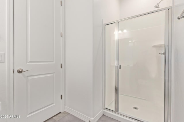 bathroom featuring baseboards and a shower stall