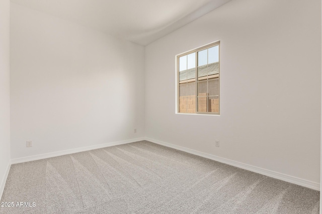 carpeted empty room featuring baseboards