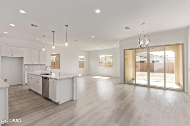 kitchen with open floor plan, visible vents, a sink, and stainless steel dishwasher