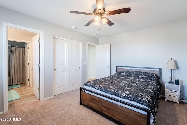 bedroom featuring light carpet, ceiling fan, and a closet