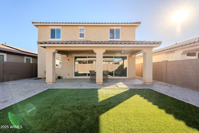 back of house with a lawn and a patio