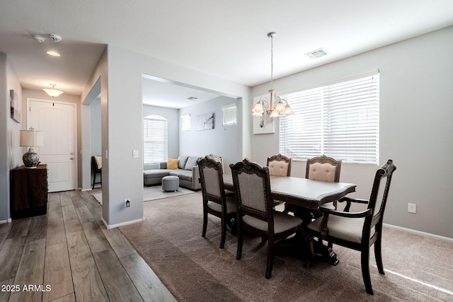 dining area with hardwood / wood-style flooring and a notable chandelier