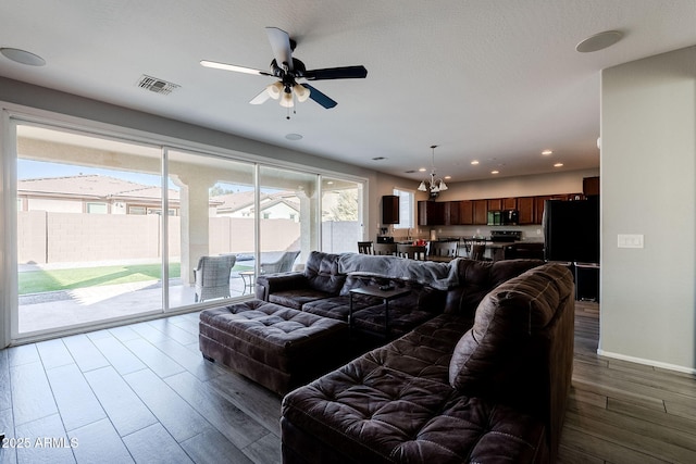 living room featuring ceiling fan, a wealth of natural light, and dark hardwood / wood-style flooring