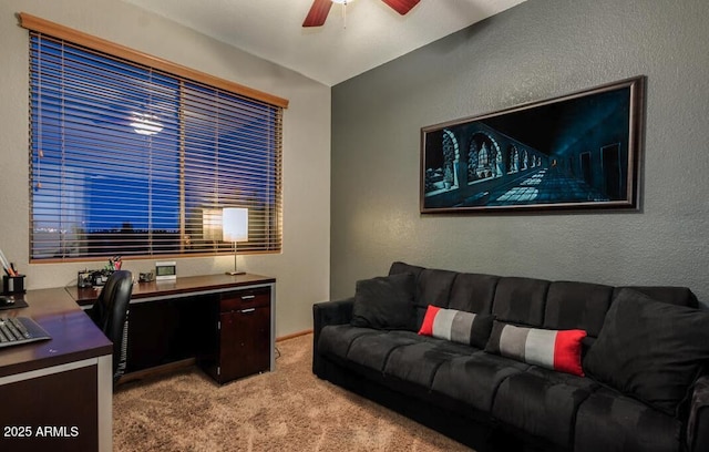 carpeted office space featuring ceiling fan