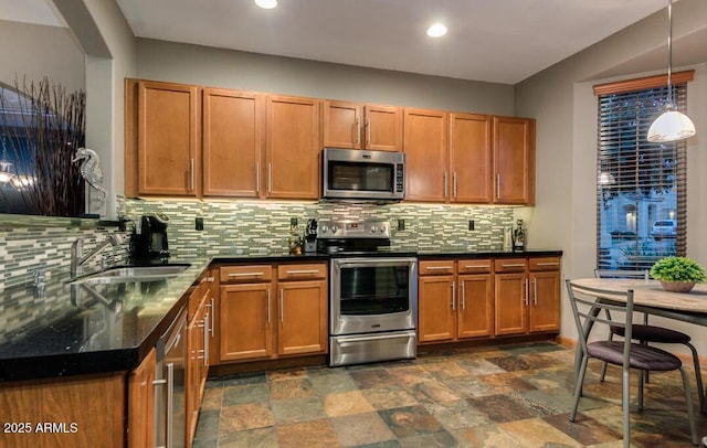 kitchen featuring pendant lighting, stainless steel appliances, sink, and decorative backsplash