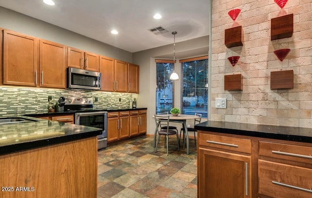 kitchen featuring tasteful backsplash, appliances with stainless steel finishes, sink, and pendant lighting