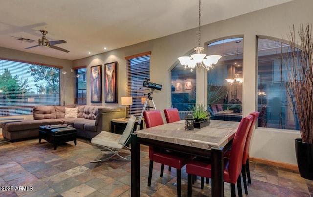 dining area featuring ceiling fan with notable chandelier