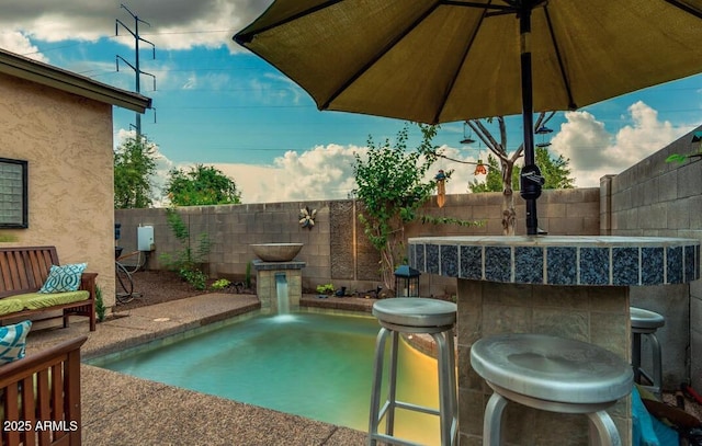 pool at dusk with an outdoor bar