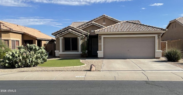 single story home featuring an attached garage, a tile roof, concrete driveway, and stucco siding