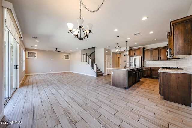 10036 E Naranja Ave, Mesa, AZ 85209 - kitchen featuring stainless steel appliances, open floor plan, light countertops, decorative light fixtures, and an island with sink