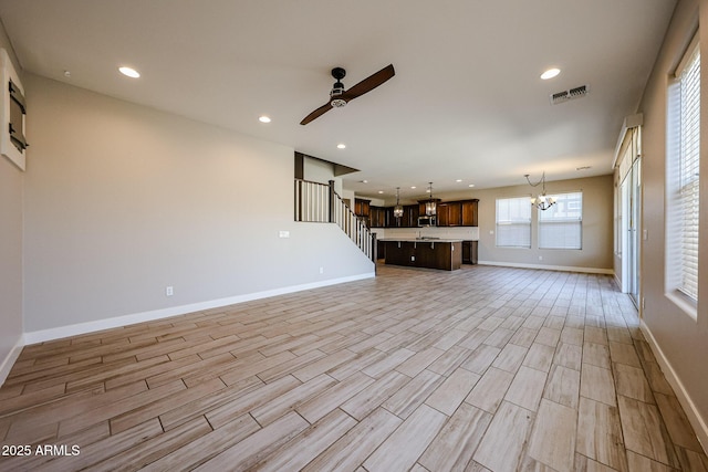 10036 E Naranja Ave, Mesa, AZ 85209 - unfurnished living room with ceiling fan, a chandelier, recessed lighting, light wood-style flooring, and stairway