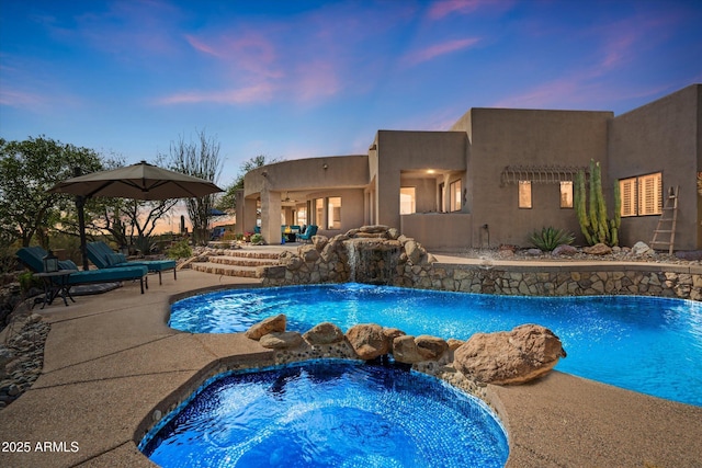 outdoor pool featuring an in-ground hot tub and a patio area
