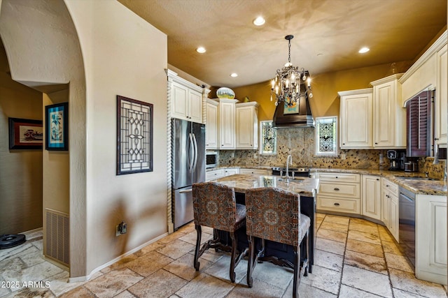 kitchen featuring stone tile flooring, appliances with stainless steel finishes, recessed lighting, decorative backsplash, and light stone counters