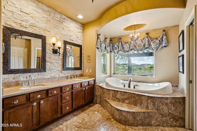 bathroom featuring a bath, double vanity, marble finish floors, and a chandelier
