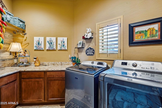laundry room featuring independent washer and dryer and cabinet space
