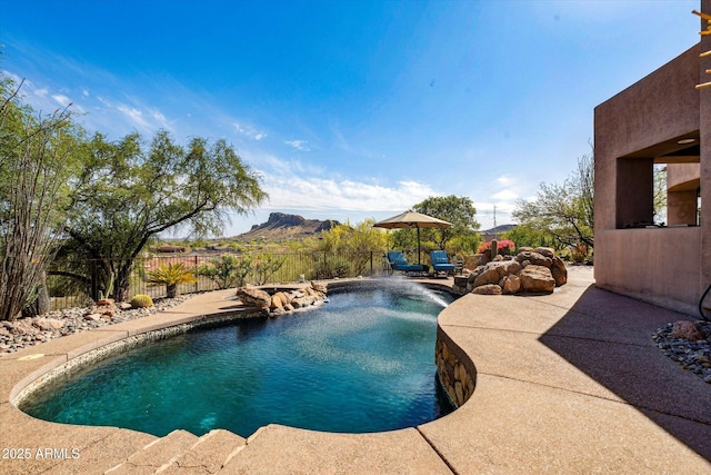 view of pool with fence, a patio, and a mountain view