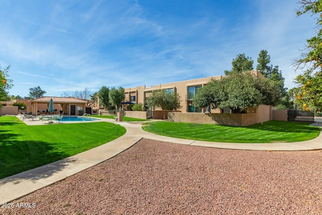 view of community featuring fence, a pool, a gazebo, a lawn, and a patio area