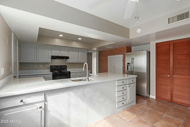 kitchen with stainless steel refrigerator with ice dispenser, light countertops, visible vents, a sink, and black / electric stove