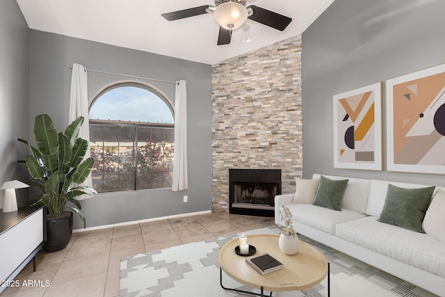 living area with light tile patterned floors, a large fireplace, baseboards, a ceiling fan, and lofted ceiling