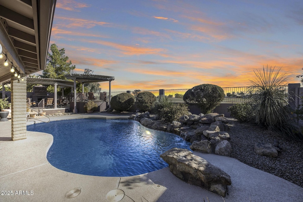 pool at dusk featuring a patio, pool water feature, and a pergola