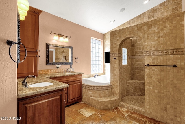 bathroom with independent shower and bath, vaulted ceiling, and vanity