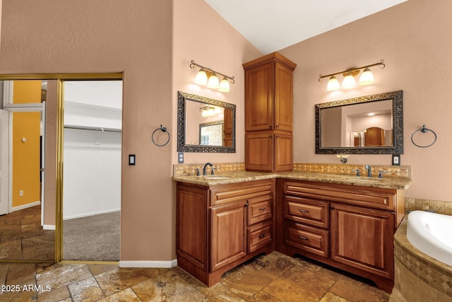 bathroom with a relaxing tiled tub, lofted ceiling, and vanity