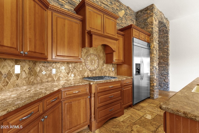 kitchen with light stone counters, decorative backsplash, and appliances with stainless steel finishes