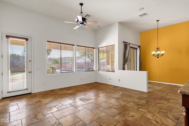 interior space featuring ceiling fan with notable chandelier and a high ceiling